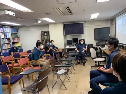 A group of people sitting in a room with computers

Description automatically generated with medium confidence